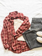 Women's comfortable casual clothes - gray jeans, red plaid shirt, t-shirt and sneakers on a light background, top view
