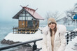 Woman tourist sightseeing Kansa Shrine and Lake Tazawa in winter. Traveler travel in Semboku city, Akita Prefecture, Japan. Landmark for tourist attraction in Tohoku region. Japan travel and vacation