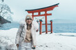 Woman tourist sightseeing Japanese Torii gate  Shrine and lake Tazawa. Traveler travel in Semboku city, Akita Prefecture, Japan. Landmark for tourist attraction in Tohoku. Japan travel and vacation