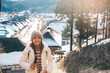 Woman tourist sightseeing Ouchi Juku ancient farmer house village with snow in winter, Traveler travel in Shimogo town, Minamiaizu, Fukushima Prefecture, Tohoku Region, Japan. Landmark and vac