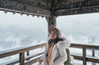 Woman tourist sightseeing view of village with snow in winter from mountain viewpoint of Yamadera temple or Risshakuji temple located in Yamagata City, in Yamagata Prefecture, Tohuku, Japan