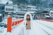 Woman tourist sightseeing Yamadera village with snow in winter, traveler travel Risshakuji temple in Yamagata City, in Yamagata Prefecture, Tohuku, Japan. Landmark for tourists attraction in Japan