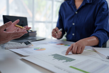 Wall Mural - Team of business people working at office. Analyzing, discussing and recording financial budget results, investments, project plans, business operations based on graph documents. chart into laptop.