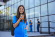 Portrait cute female surgeon breathing fresh air during lunch break, holding glass of coffee and looking at camera. Copy space. People, profession and healthcare concept.