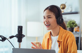 Fototapeta  - Young Asian woman use microphones wear headphones with laptop record podcast interview for radio. Content creator concept.