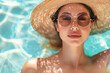 A woman wearing a straw hat and sunglasses is laying in a pool