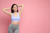 Fototapeta Koty - Happy young woman with slim body posing on pink background, space for text