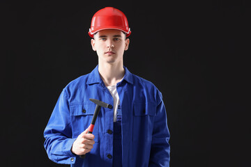 Poster - Professional repairman holding hammer on black background. Space for text