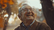 A happy old age. An elderly handsome gray-haired man with glasses is smiling and wearing a brown sweater. He looks happy and contented