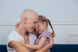 Strong woman cancer fighter have a hug from her little daughter