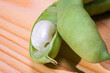 Macro detail of a green bean and its grain. Vegetable concept on a wooden background. Photo of natural and vegetarian diet.