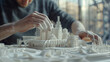 A man builds a model of a city made of white plastic. The city is printed on a 3D printer. The model is very detailed