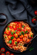 Italian spaghetti in bolognese sauce with meatballs, black table background, top view