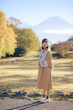 Casual dress elegance, Asian woman enjoys fall in Japan. Kyoto portrait with colorful maple foliage, capturing her cheerful smile and the refreshing beauty of the changing season.