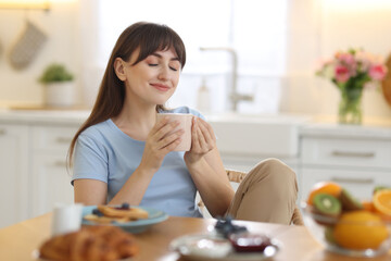 Sticker - Beautiful woman drinking coffee at breakfast indoors