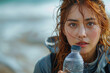 A woman with red hair is holding a bottle of water