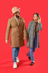 Canvas Print - Happy couple in love walking on red background