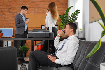 Wall Mural - Business colleagues having coffee break in office