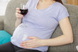 pregnant woman holding a glass of wine