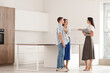 © Pixel-Shot - Female real estate agent showing young couple kitchen in new house