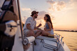 Couple having fun drinking champagne and sailing on a boat while on summer vacation