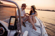 Couple sailing to the sunset on a boat while on summer vacation