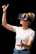 Woman Exploring Wearing Virtual Reality Headset Against Black Studio Background