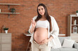 © Pixel-Shot - Young pregnant woman with serum at home