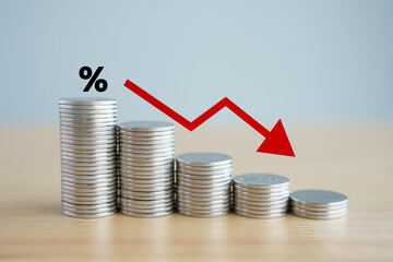 Interest rate finance and mortgage rates. Percentage sign on stack of coins and arrow down, financial, interest rate, reduction, sale price and tax concept.