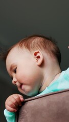 Poster - Funny boy with sticking out hair standing on a chair. Kid holding both hands on a chair back and turning his head away from camera. Low angle view. Blurred backdrop. Vertical video