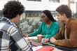 © EFStock - African American Woman together with university students working and learning together discussing about project