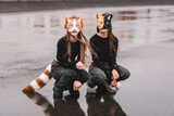 Fototapeta Przestrzenne - Teenage girls with cat mask and gloves doing Quadrobics. girls in a cat mask is lying on the grass.