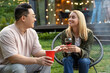 Diverse friends sitting together on backyard with drinks enjoying weekend party