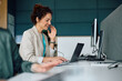 © Drazen - Happy businesswoman having conference call via laptop while working in office.