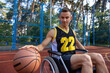 Young guy athlete having disability in wheelchair having basketball training