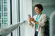 © Drazen - Smiling businesswoman using mobile phone in office.