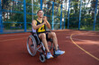Smiling guy with disability maneuvering wheelchair on basketball training