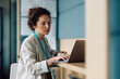 © Drazen - Female entrepreneur using laptop while working in office.