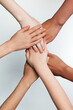 © Lustre Art Group  - Close up of children putting their hands together against grey background. Friends with stack of hands showing unity and teamwork. Concept of youth, expression, unity, emotions, gestures, support.