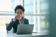 © Drazen - Businesswoman having  glass of water while working on laptop in office.