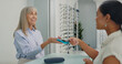 © peopleimages.com - Shopping, credit card and people with contactless payment for retail service and eye care at store. Tap, machine and optometrist with customer with bank purchase transaction at optical shop.