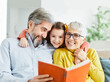 © Lumos sp - grandchild family child grandparent grandmother book reading elderly granddaughter girl  happy together read learning education woman grandfather