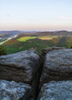 View from above of green meadows and fields, neat houses in the valley and the Elbe River. Saxon Switzerland National Park, Germany.