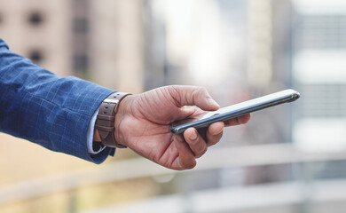 Leinwandbilder - Businessman, hand and browsing with phone in city for communication, social media or texting. Closeup of man or employee typing on mobile smartphone for online chatting, app or news in an urban town