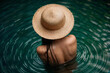 Asian girl in straw Hat  in riverl. Female back. Young beautiful woman relaxing in water