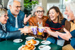 Happy senior people having breakfast sitting at cafe bar - Food and beverage lifestyle concept