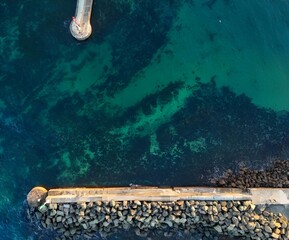 Sticker - Aerial view of rocky shore by turquoise sea