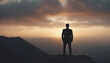 © abu - silhouette of a businessman in a suit standing on a high mountain peak