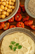 Healthy, vegan dip with chickpea, sesame seeds, and Ethiopian eggplant. On the side are the main ingredients: cooked chickpea, unshelled sesame seeds, and dried Ethiopian eggplant.
