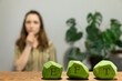 Letters EFT written on green painted wooden blocks. Female tapping chin (CH) meridian point in blurred background. Emotion-focused therapy treatment concept.